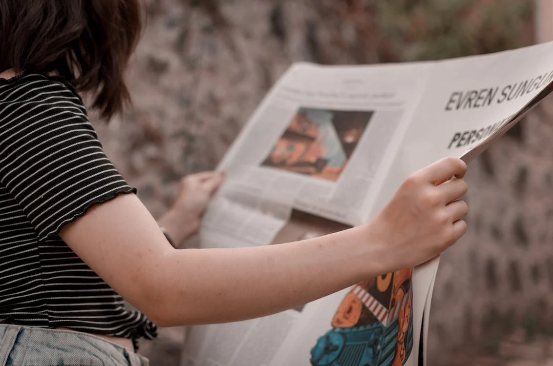 pessoa sentada lendo jornal